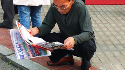 Squatting-reading-paper Squatting-reading-paper